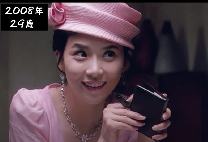 韓国女優イ・ボヨンが29歳（2008年）映画「ワンスアポンアタイム」に出演した際の顔画像。ピンク色の帽子とドレスを着て、派手なネックレスをしている。